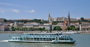 Cruise ship on the Danube with Budapest skyline featuring Fisherman's Bastion and Matthias Church.