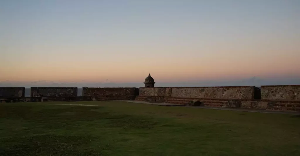 Puerto Rico Food & Drink Guide: Must-Try Flavors 2 Peaceful sunset view of a historic fort in San Juan, Puerto Rico with clear skies.