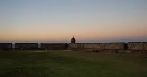 Peaceful sunset view of a historic fort in San Juan, Puerto Rico with clear skies.
