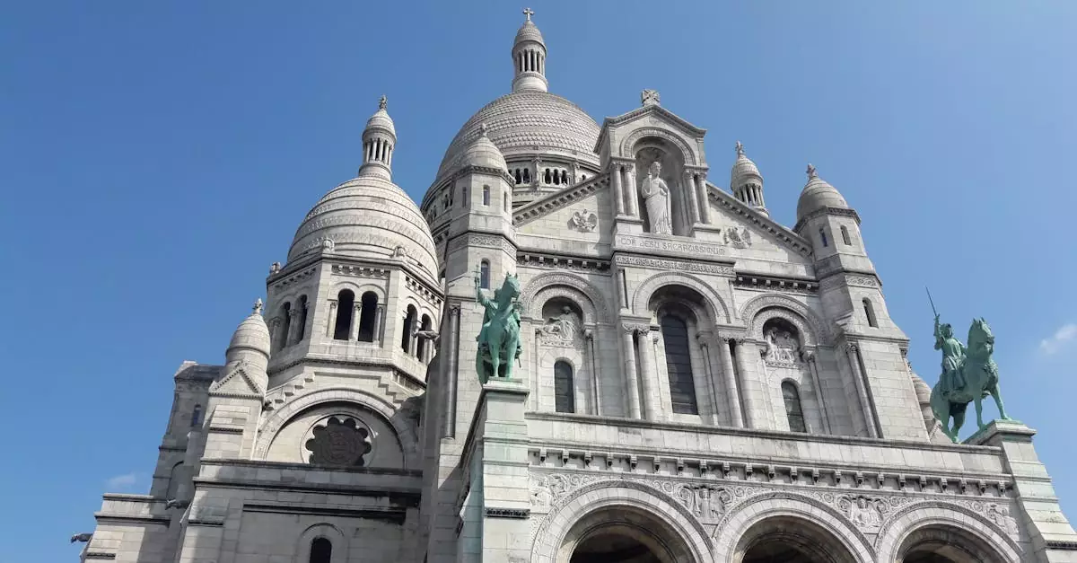 Stunning architectural view of Sacr&eacute;-C&oelig;ur Basilica in Paris under clear blue skies.