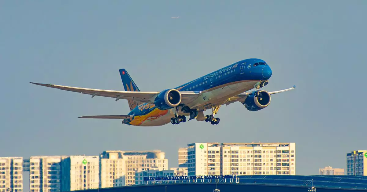Vietnam Airlines plane taking off from Ho Chi Minh City airport with urban skyline background.