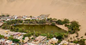 Stunning aerial shot of Huacachina oasis surrounded by desert dunes in Ica, Peru.
