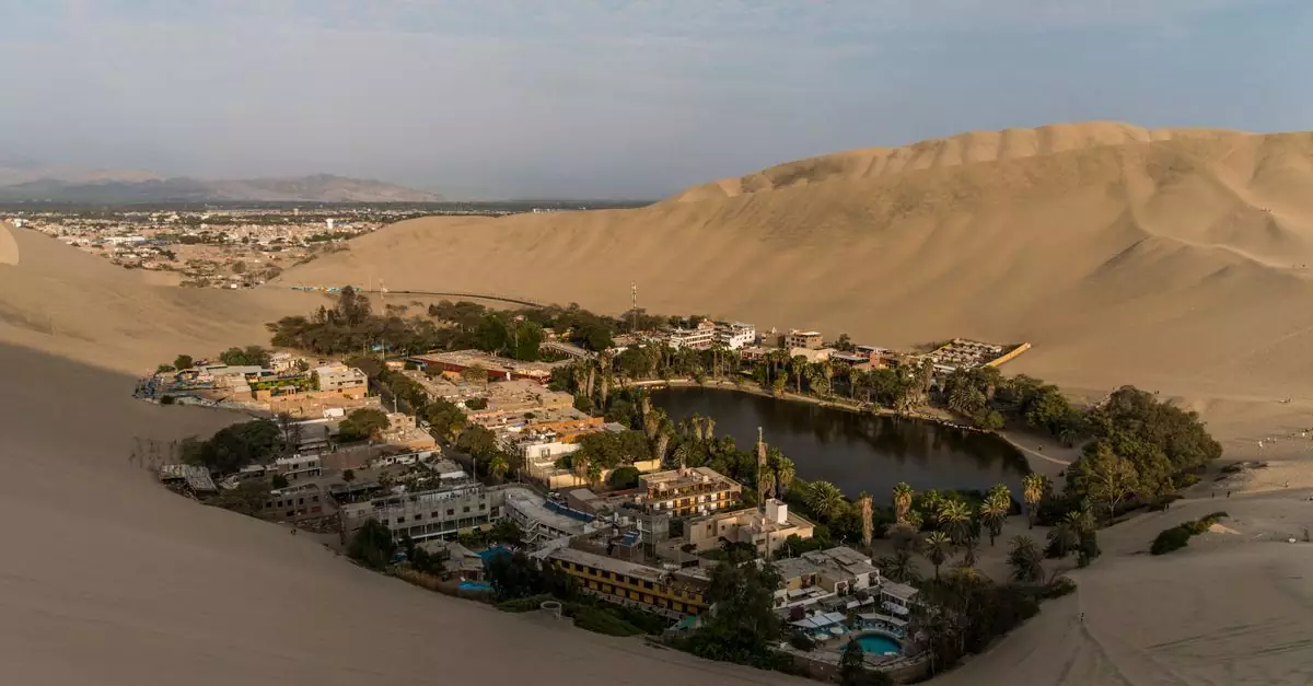 Stunning aerial view of Huacachina oasis surrounded by sand dunes in Ica, Peru.
