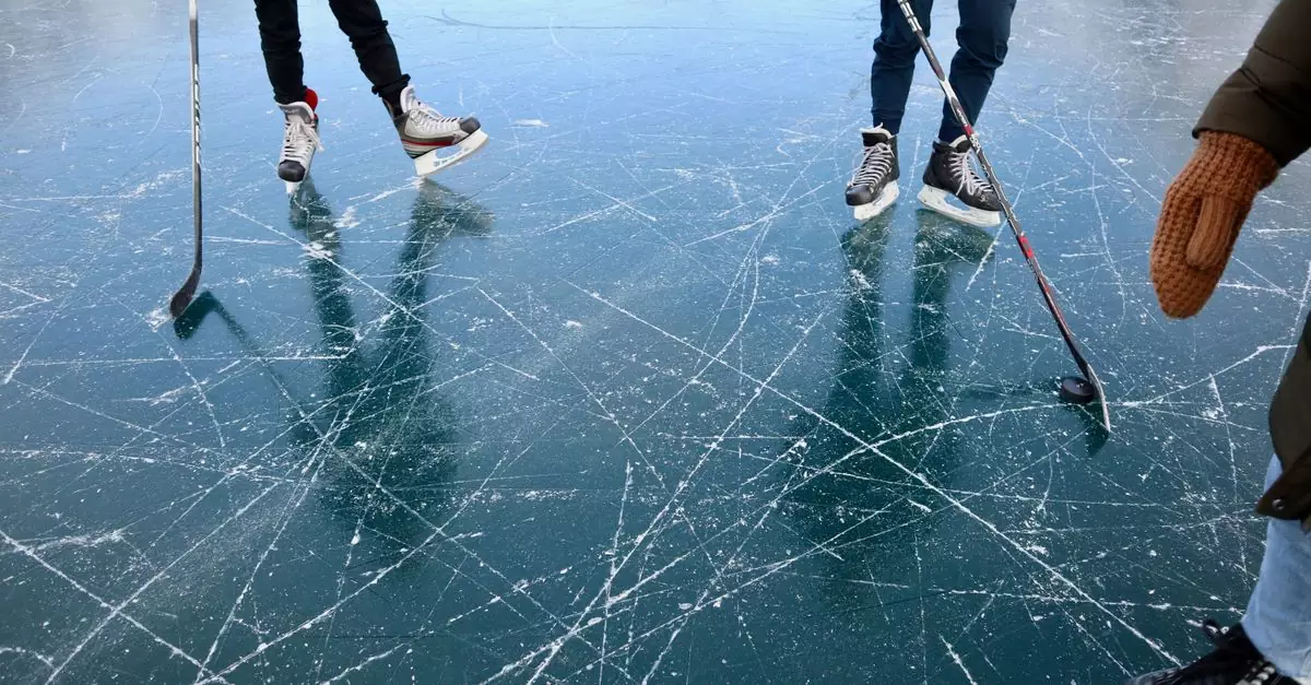 Close-up of people playing ice hockey on a frozen lake in Alberta.