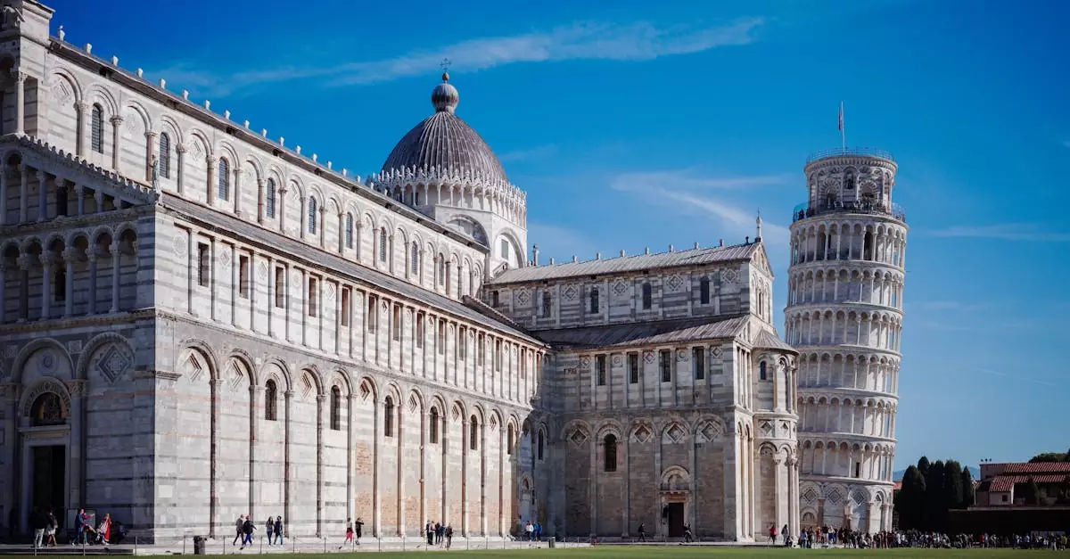 Iconic view of the Leaning Tower and Pisa Cathedral in Tuscany, Italy, on a clear sunny day.
