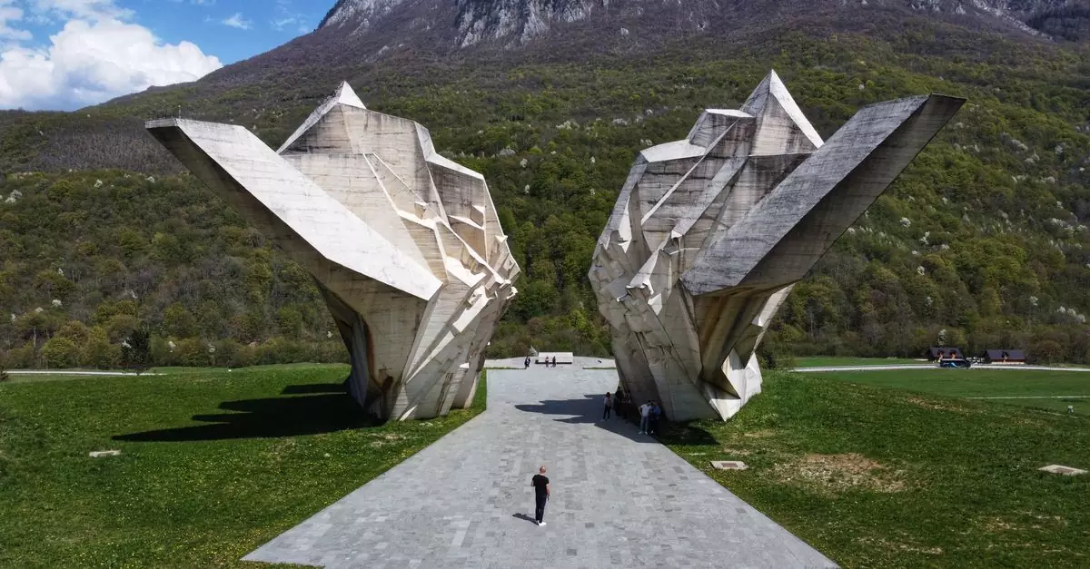 A striking view of the Sutjeska Monument in Tjenti&scaron;te Valley, Bosnia, surrounded by mountains.