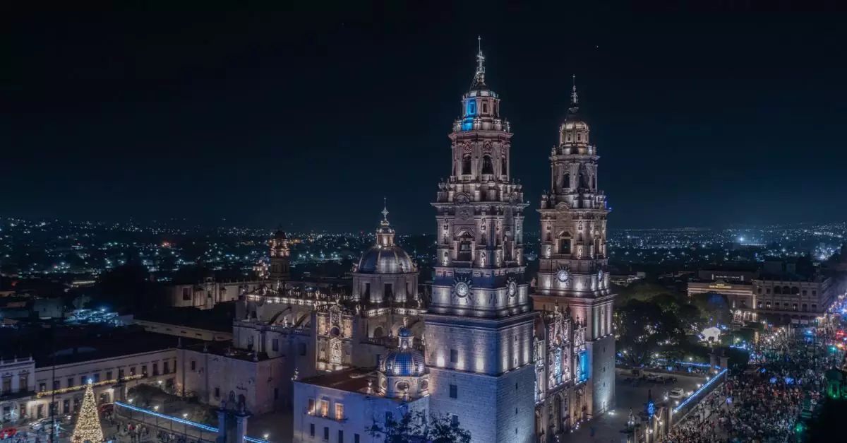 Nighttime aerial view of the illuminated Morelia Cathedral in Mexico, with vibrant city lights.