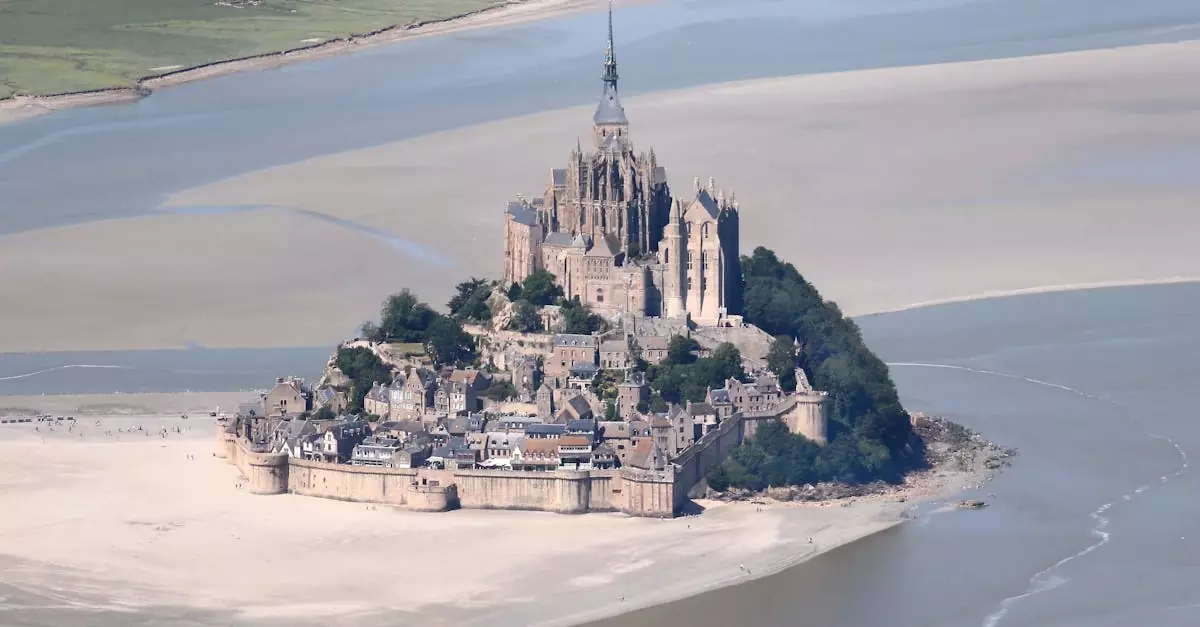 Stunning aerial shot of the iconic Mont Saint-Michel surrounded by tidal waters in Normandy, France.