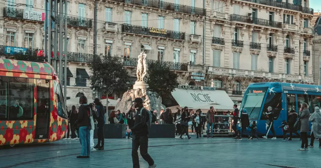 Montpellier: Top Things to Do & See in France 9 Vibrant street view in Montpellier with colorful trams and classic architecture.