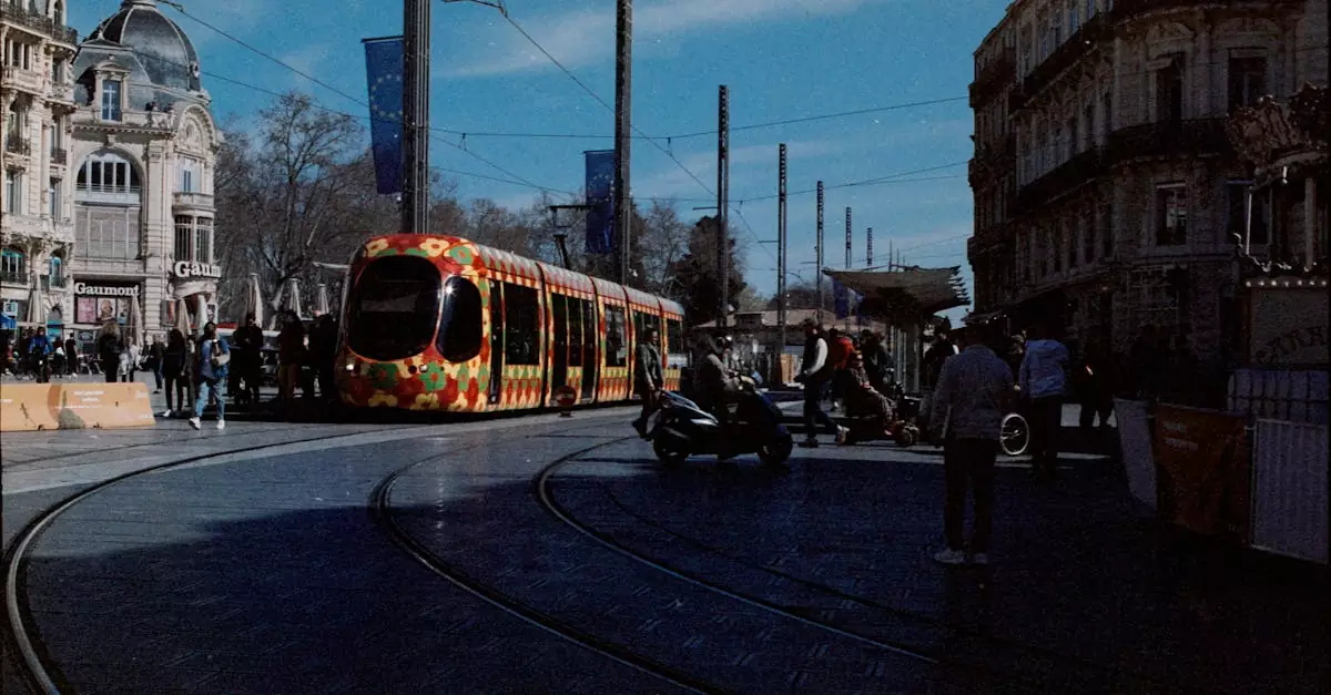 Colorful tram passing through a bustling street in Montpellier, France.