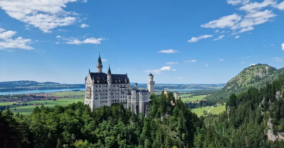 Stunning aerial view of Neuschwanstein Castle in Bavaria, Germany, surrounded by lush greenery.