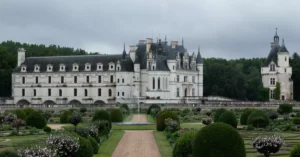 A stunning view of the Château de Chenonceau surrounded by vibrant gardens in Chenonceaux, France.