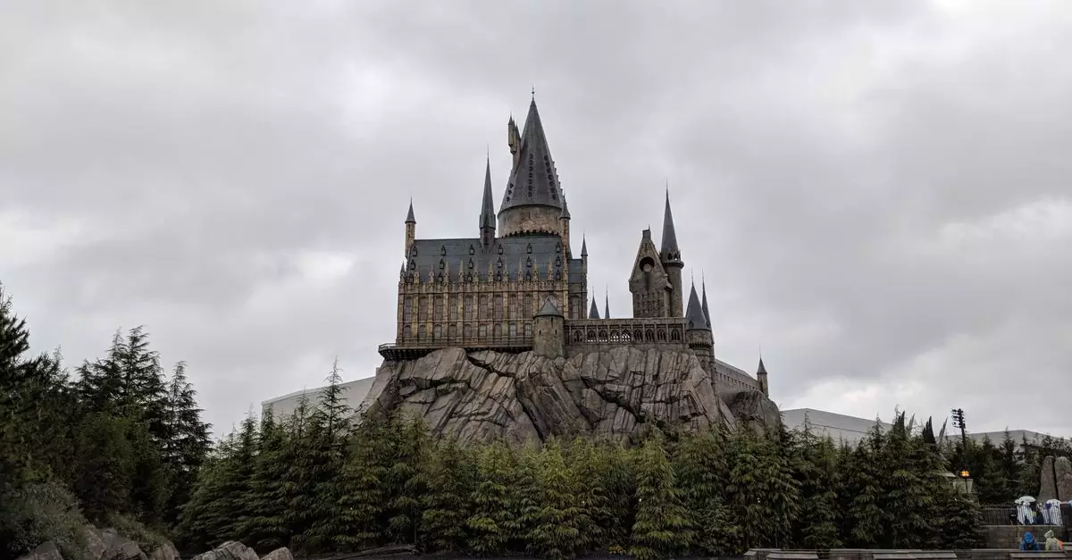 Majestic exterior view of Hogwarts Castle at Universal Studios Japan with a scenic water reflection.