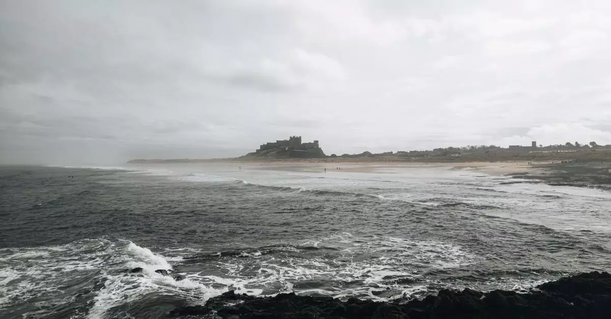 A dramatic scene of Bamburgh Castle overlooking the rugged Northumberland coast in England.