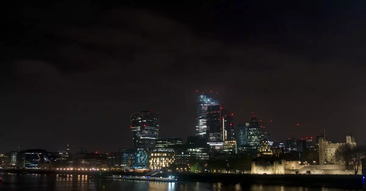 Dramatic night view of London's skyline featuring modern skyscrapers and the historical Tower of London.