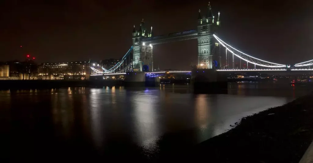 Illuminated Tower Bridge at night over the Thames in London, a renowned UK landmark.