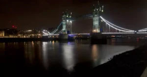 Illuminated Tower Bridge at night over the Thames in London, a renowned UK landmark.