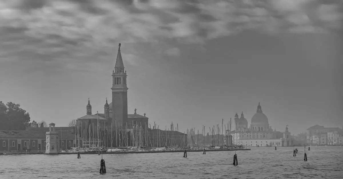 Moody black and white view of Venice's historic architecture with cloudy skies.