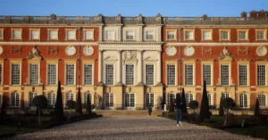 Stunning view of the Hampton Court Palace facade, showcasing baroque architecture and gardens in Molesey, England.