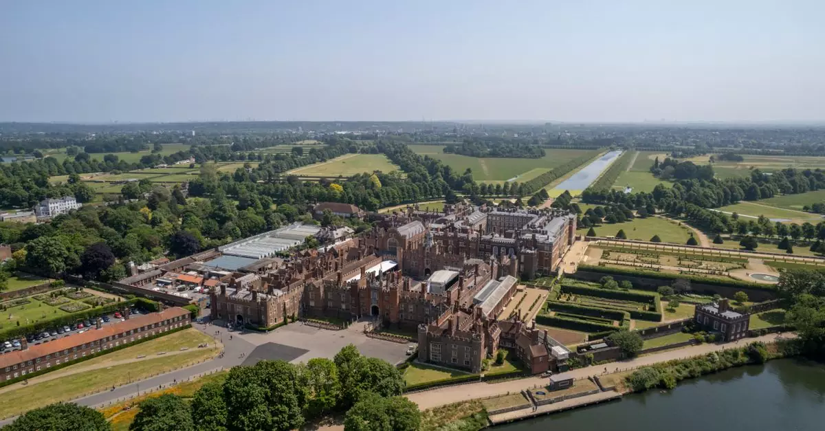 A stunning aerial view of Hampton Court Palace surrounded by lush greenery in Molesey, England.