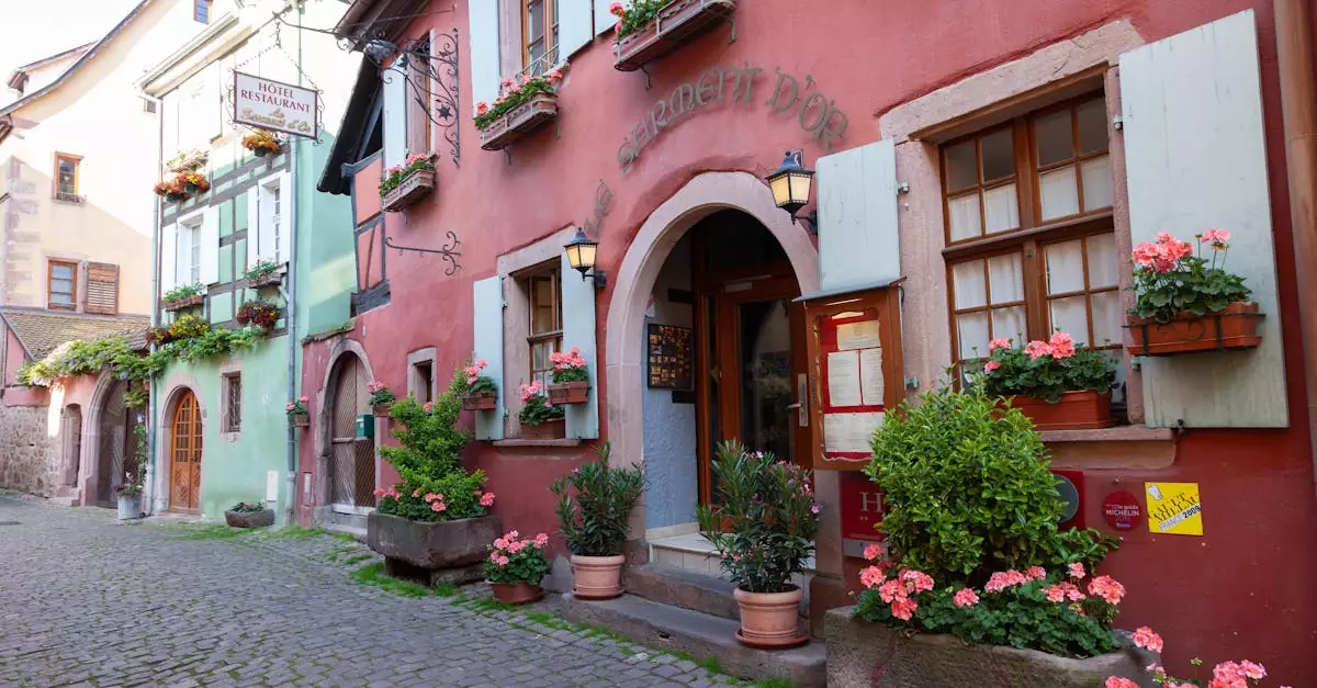 Picturesque cobblestone street in Riquewihr, France with colorful buildings and vibrant flowers.