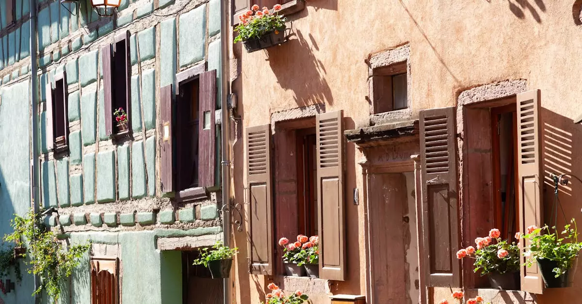 Picturesque half-timbered houses in Riquewihr, France, adorned with vibrant flower boxes under the warm sunshine.