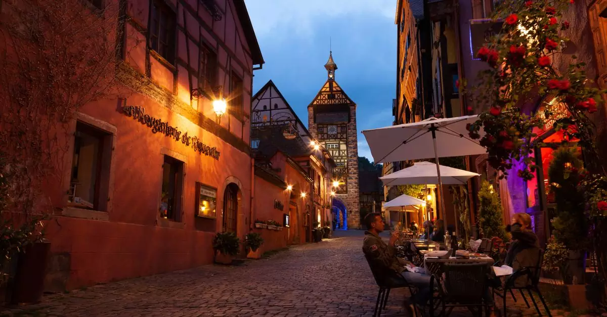 A picturesque evening scene from Riquewihr, France, showcasing cobblestone streets and medieval architecture.