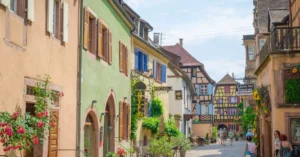 Picturesque street in Alsace, France showcasing vibrant facades and classic European architecture on a sunny day.