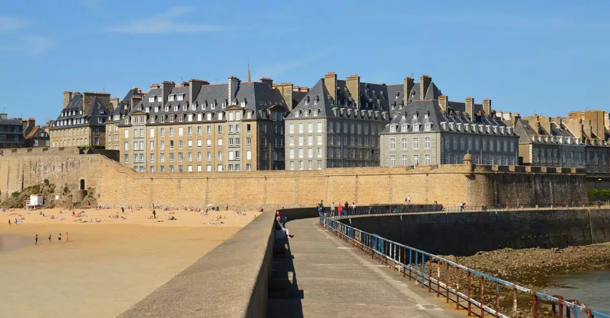 Historic Saint-Malo beach and walls under blue skies, perfect for travel and architecture.
