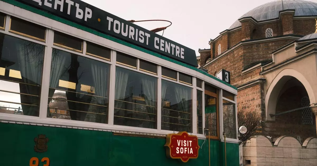Colorful tram passes by Banya Bashi Mosque in Sofia, featuring a tourist center sign.