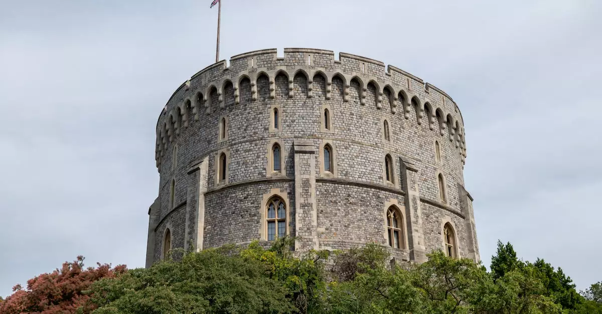 Historic tower of Windsor Castle surrounded by lush greenery, England.