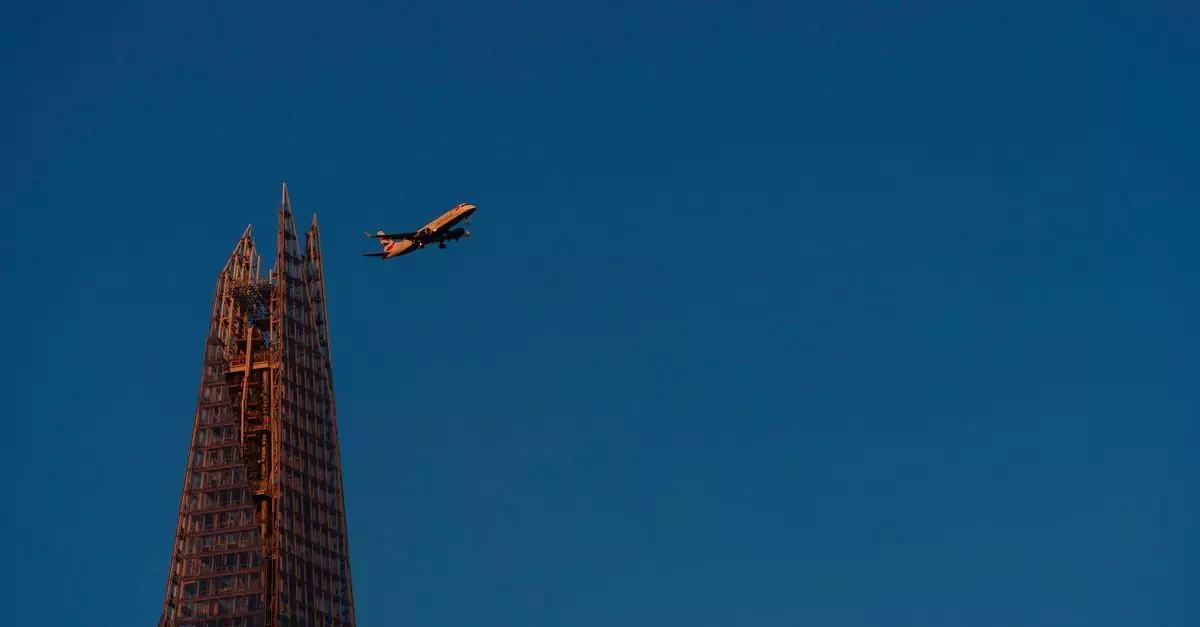 Airplane passing over The Shard in London, lit by the warm colors of the setting sun against a clear sky.