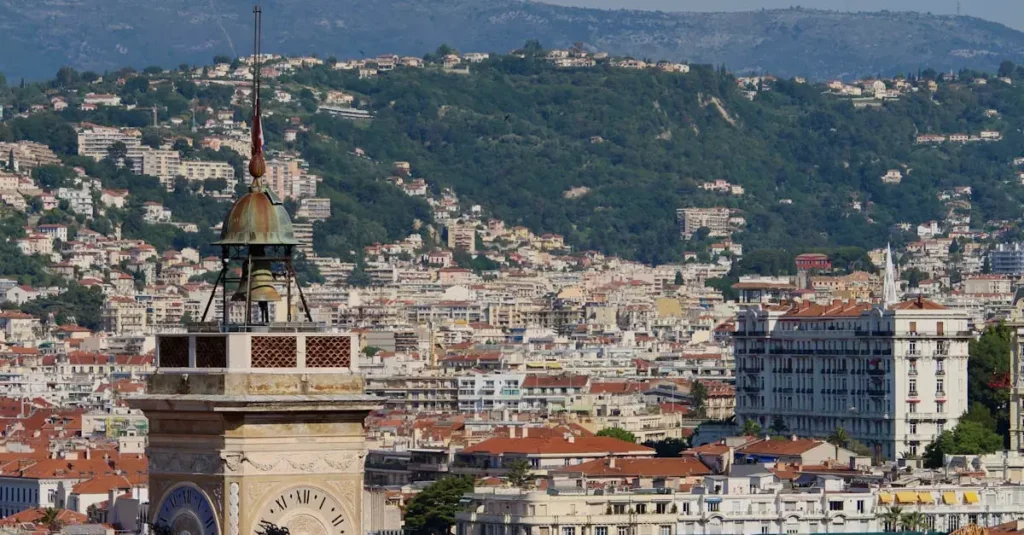 Weekend in Nice, France: Itinerary & Hidden Gems 12 A stunning view of a historic clock tower with the cityscape of Nice, France in the background.