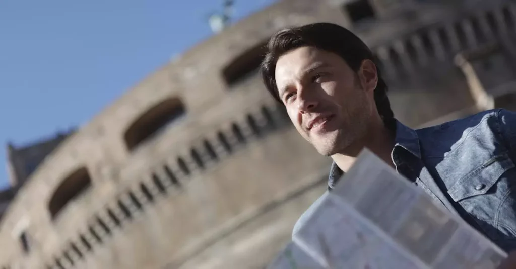 Man in denim jacket sightseeing near historical building, enjoying travel with map.