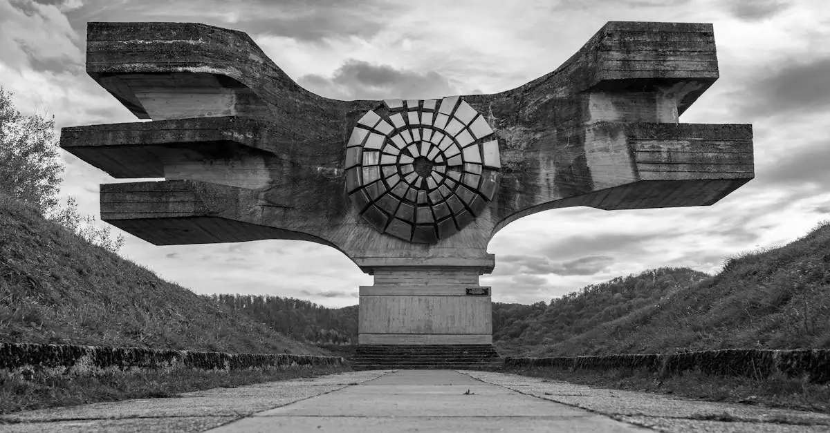 Black and white photo of the striking Podgarić Monument surrounded by cloudy skies, Croatia.